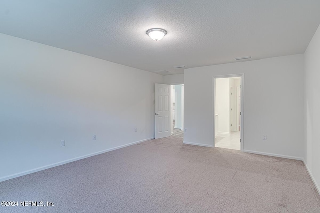 carpeted empty room with a textured ceiling