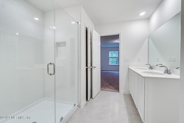 bathroom with tile patterned floors, walk in shower, and vanity