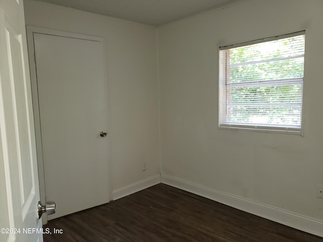 unfurnished room with a wealth of natural light and dark hardwood / wood-style floors