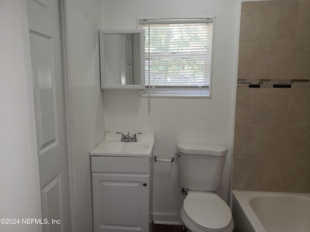 full bathroom featuring tiled shower / bath combo, vanity, and toilet