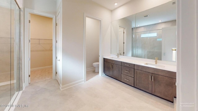 bathroom with vanity, toilet, and a shower with shower door