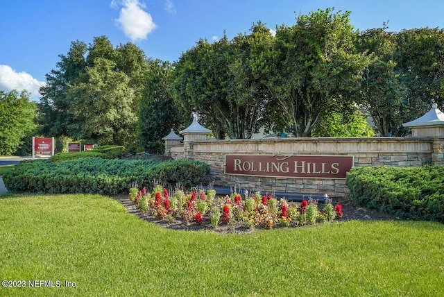 community / neighborhood sign featuring a yard