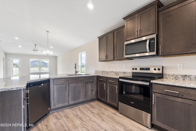 kitchen with light wood-style flooring, appliances with stainless steel finishes, a peninsula, dark brown cabinets, and a sink