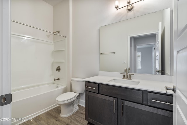 bathroom featuring toilet, shower / washtub combination, wood finished floors, and vanity