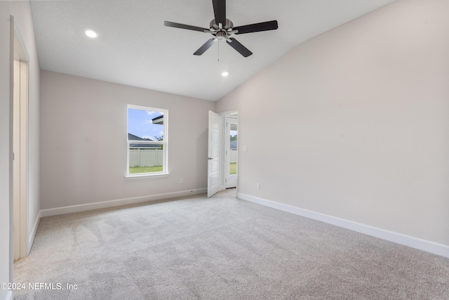 spare room featuring recessed lighting, light carpet, vaulted ceiling, and baseboards