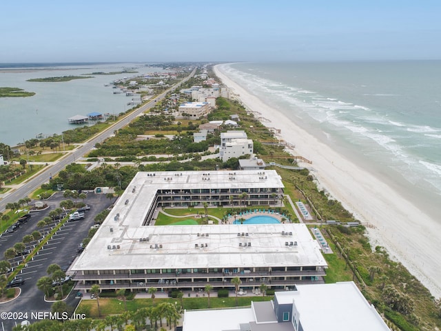 birds eye view of property with a water view and a beach view