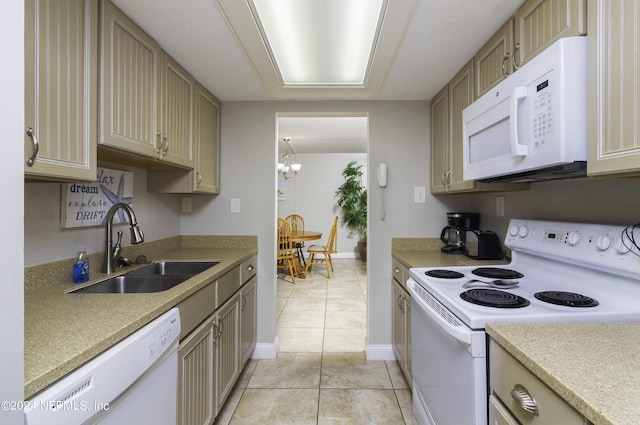 kitchen featuring light tile patterned floors, light countertops, a sink, white appliances, and baseboards