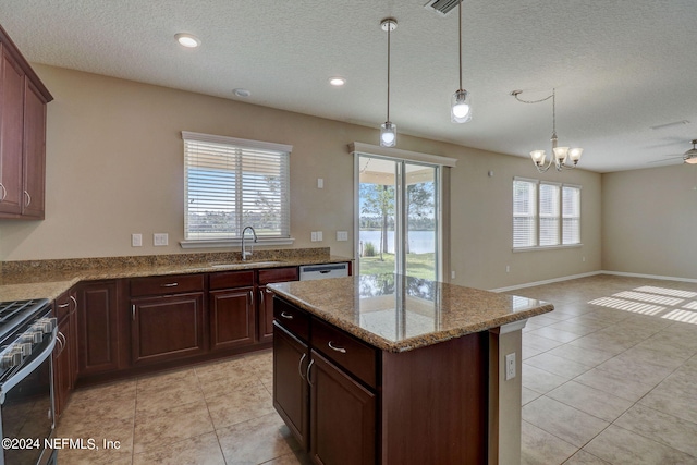 kitchen featuring light tile floors, range, sink, ceiling fan with notable chandelier, and hanging light fixtures