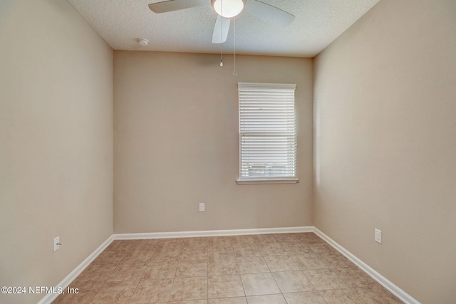 tiled spare room with ceiling fan and a textured ceiling