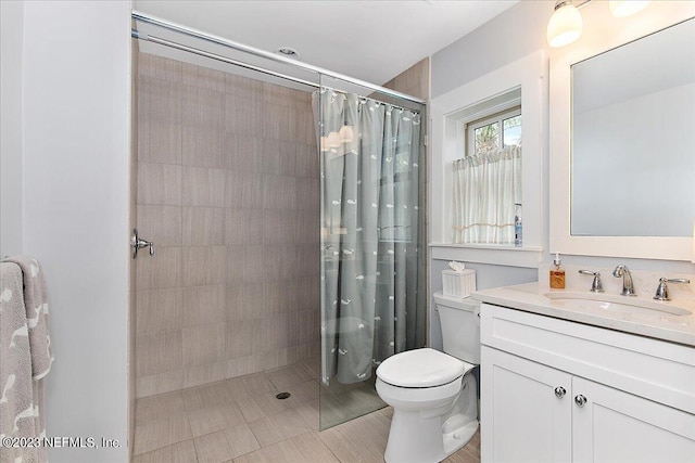 bathroom featuring tile floors, toilet, large vanity, and a shower with shower curtain