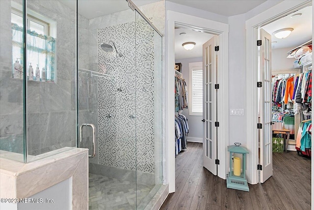 bathroom with hardwood / wood-style flooring and an enclosed shower