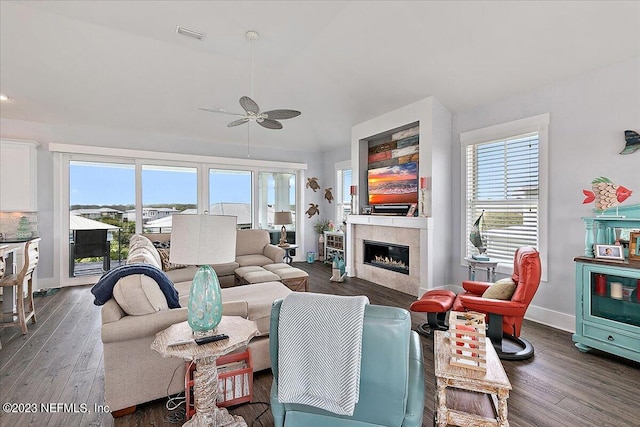 living room with plenty of natural light, dark hardwood / wood-style flooring, ceiling fan, and a fireplace