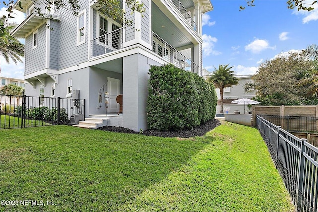 view of property exterior with a balcony and a lawn