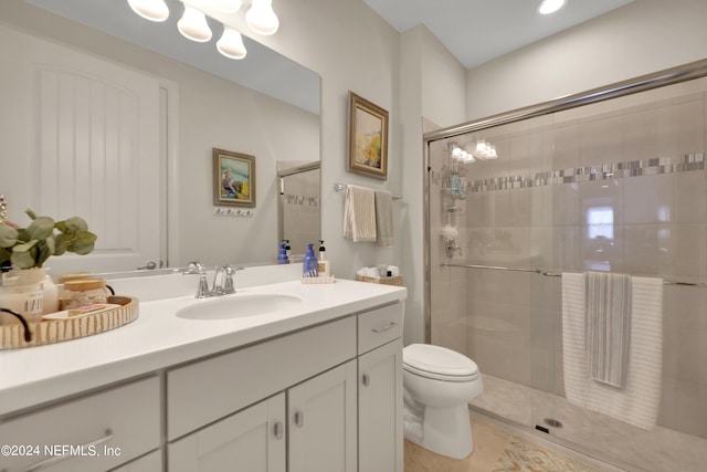 bathroom featuring an enclosed shower, vanity, and toilet