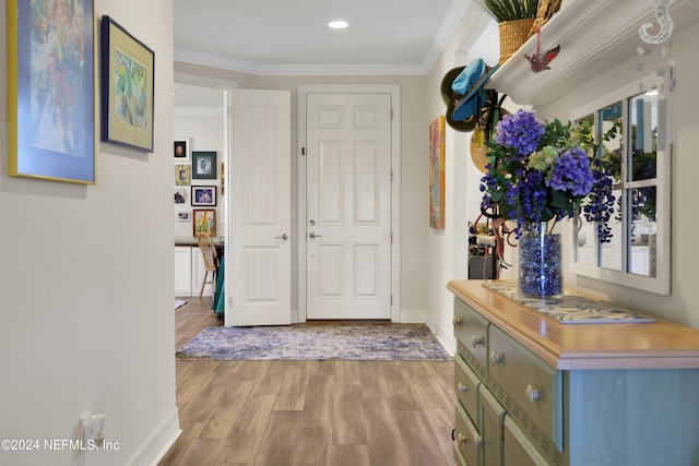 foyer featuring light wood-type flooring and ornamental molding