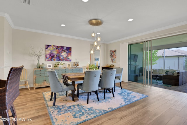 dining room featuring light hardwood / wood-style floors and crown molding