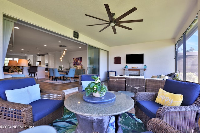 exterior space featuring ceiling fan and a fireplace