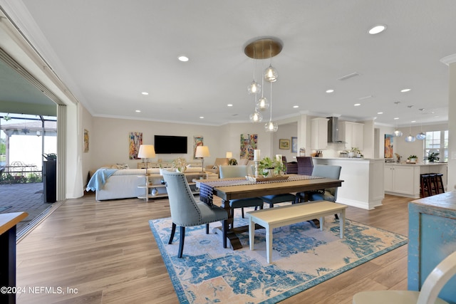 dining area with light hardwood / wood-style flooring and crown molding