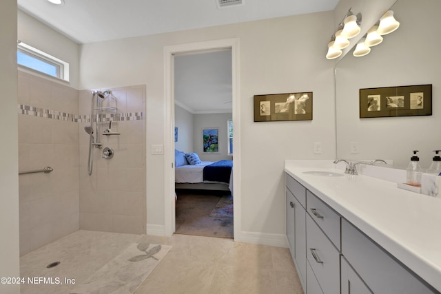 bathroom with large vanity, tile floors, a tile shower, and ornamental molding