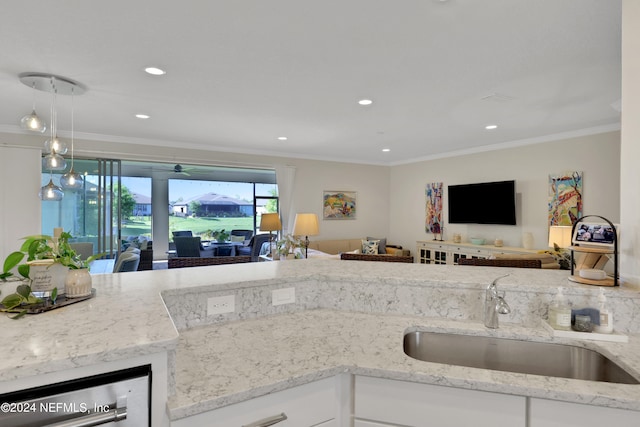 kitchen featuring sink, pendant lighting, crown molding, and white cabinetry