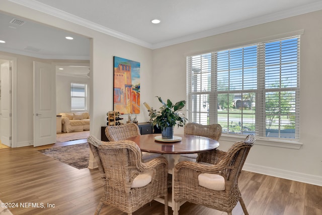 dining room featuring hardwood / wood-style floors and crown molding