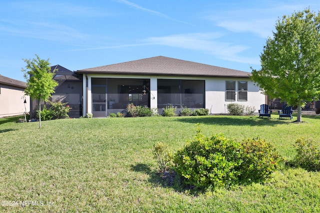 rear view of property featuring a yard and a sunroom