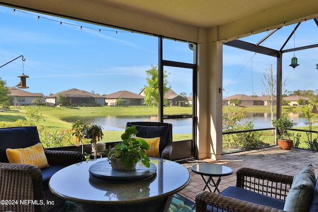 sunroom / solarium featuring a water view