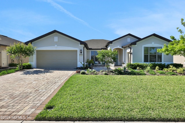 ranch-style home featuring a garage and a front lawn