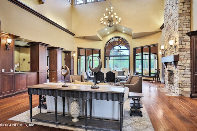 interior space featuring a chandelier, a towering ceiling, a fireplace, and dark hardwood / wood-style floors