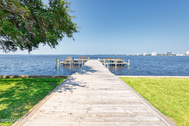 view of dock featuring a water view and a yard