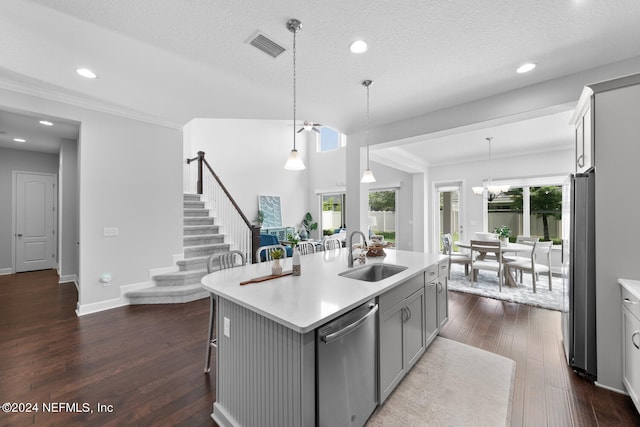 kitchen with gray cabinetry, stainless steel appliances, sink, pendant lighting, and an island with sink