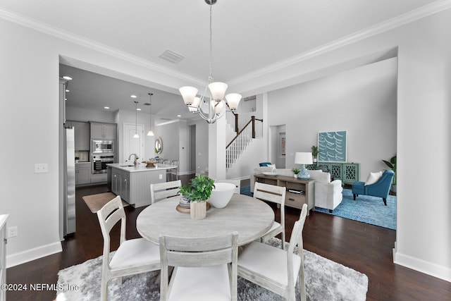 dining space featuring a chandelier, dark hardwood / wood-style flooring, ornamental molding, and sink