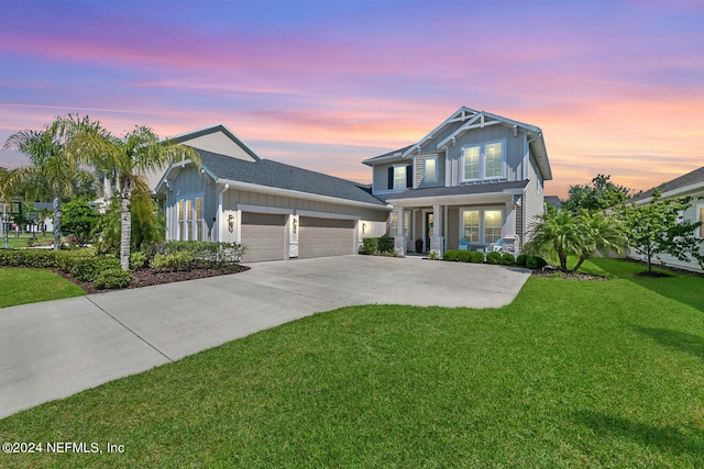 view of front of house featuring a lawn, covered porch, and a garage