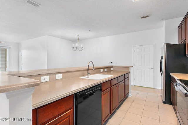 kitchen with black dishwasher, decorative light fixtures, light tile floors, sink, and a textured ceiling