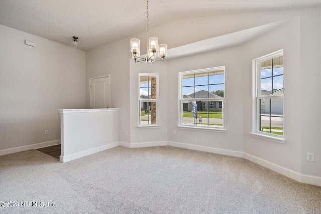 carpeted empty room featuring lofted ceiling and a notable chandelier