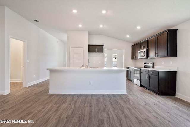 kitchen with sink, light wood-type flooring, a kitchen island with sink, and appliances with stainless steel finishes