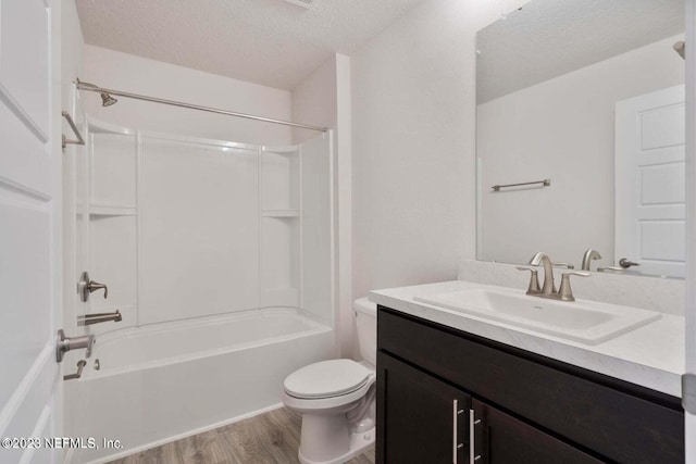 full bathroom with toilet, bathtub / shower combination, wood-type flooring, a textured ceiling, and vanity