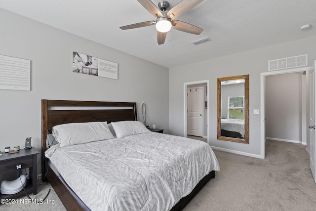 bedroom featuring ceiling fan, carpet floors, and a textured ceiling