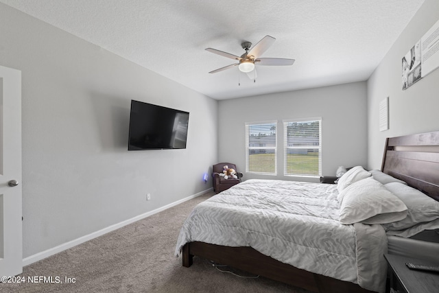 bedroom with a textured ceiling, ceiling fan, and carpet