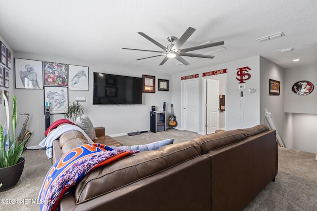 carpeted living room with ceiling fan and a textured ceiling