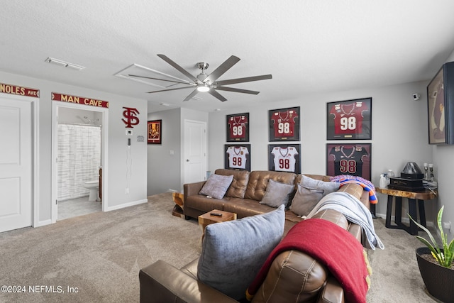 living room with a textured ceiling, carpet floors, and ceiling fan