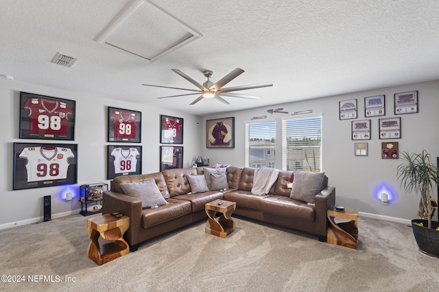 living room with ceiling fan, carpet floors, and a textured ceiling