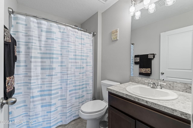 bathroom with a textured ceiling, large vanity, tile floors, and toilet