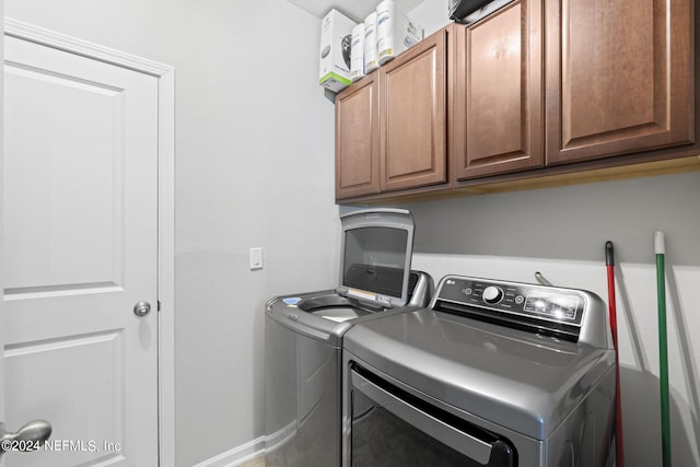 washroom with independent washer and dryer and cabinets