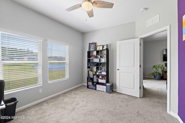 interior space featuring light colored carpet and ceiling fan