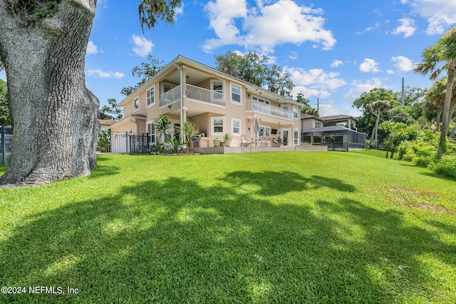 back of property featuring a yard and a balcony