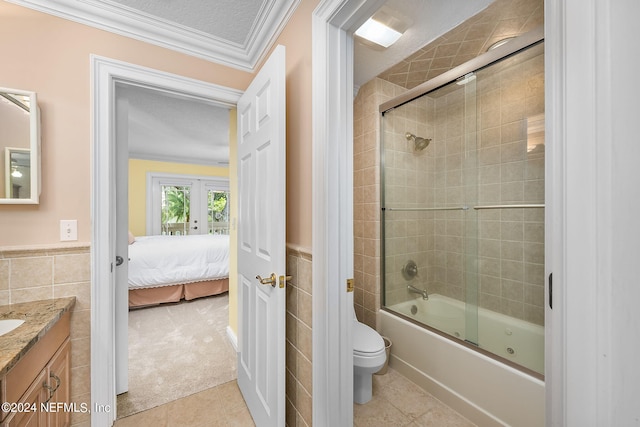 full bathroom featuring vanity, french doors, toilet, enclosed tub / shower combo, and tile walls