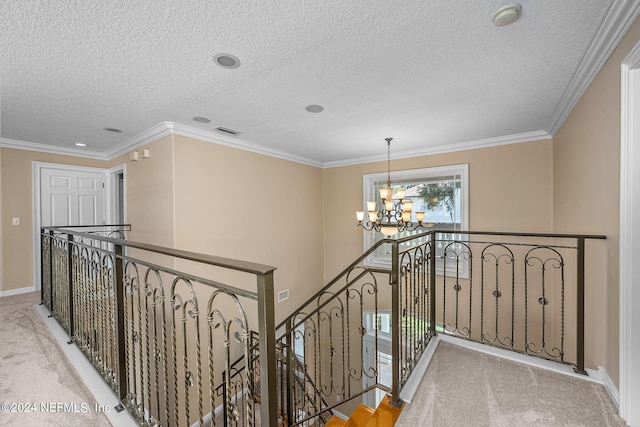 hallway with light carpet, ornamental molding, a textured ceiling, and an inviting chandelier