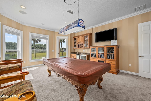 playroom featuring light carpet, a textured ceiling, crown molding, indoor bar, and pool table