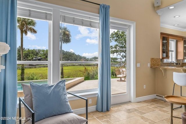 doorway featuring sink and crown molding